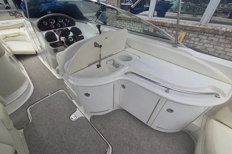 Slide: The Image of 2001 Sea Ray 290 Bow Rider interior with helm, sink, and seating area. - 18