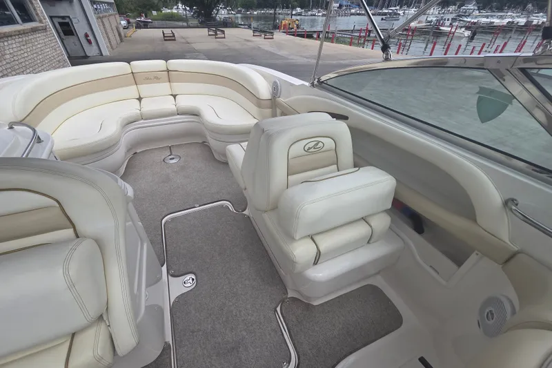 Slide: The Image of 2001 Sea Ray 290 Bow Rider interior with plush seating and waterfront view. - 15