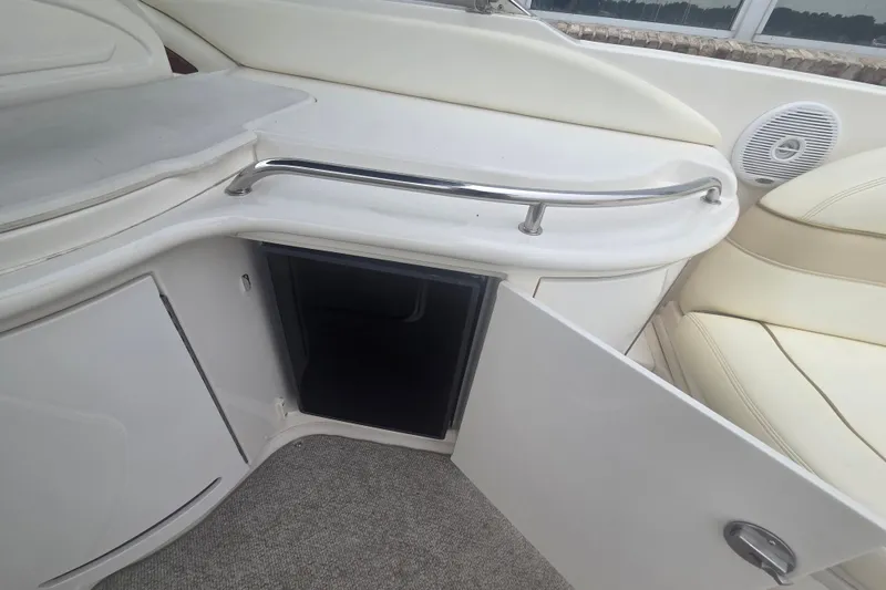 Slide: The Image of 2001 Sea Ray 290 Bow Rider interior with open storage compartment and cushioned seating. - 17