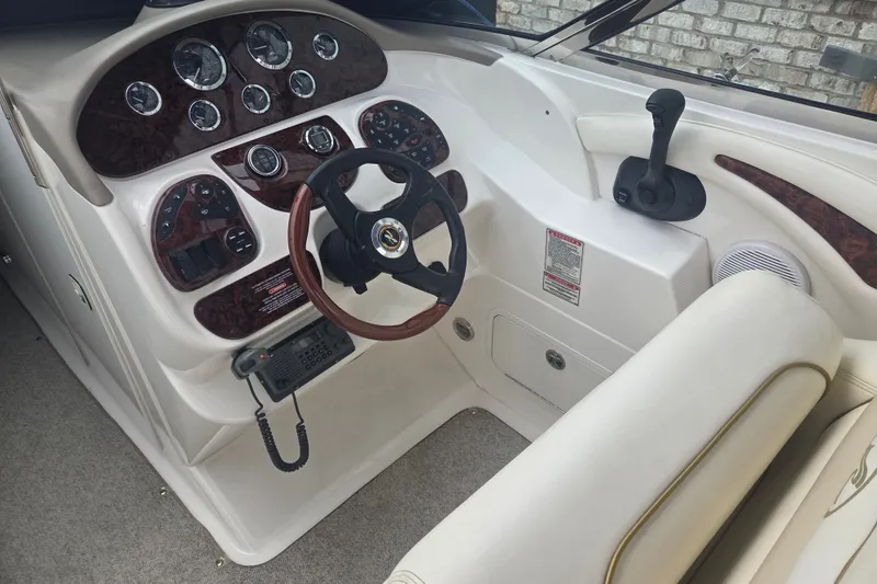 Slide: The Image of 2001 Sea Ray 290 Bow Rider helm with wood accents and modern controls. - 10