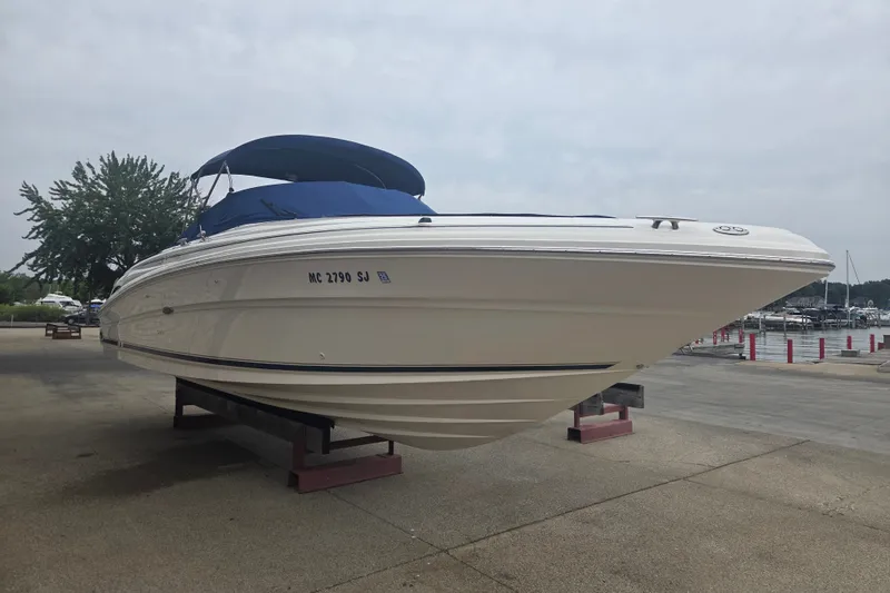 Slide: The Image of 2001 Sea Ray 290 Bow Rider boat on display near a marina. - 5