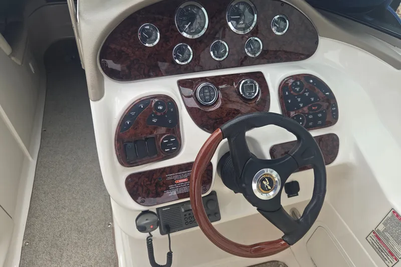 Slide: The Image of 2001 Sea Ray 290 Bow Rider dashboard with wood accents and steering wheel. - 11