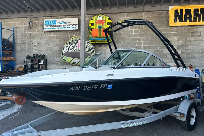 The Image of 2011 Bayliner 175 Bowrider boat on trailer, parked in a storage area. - 0