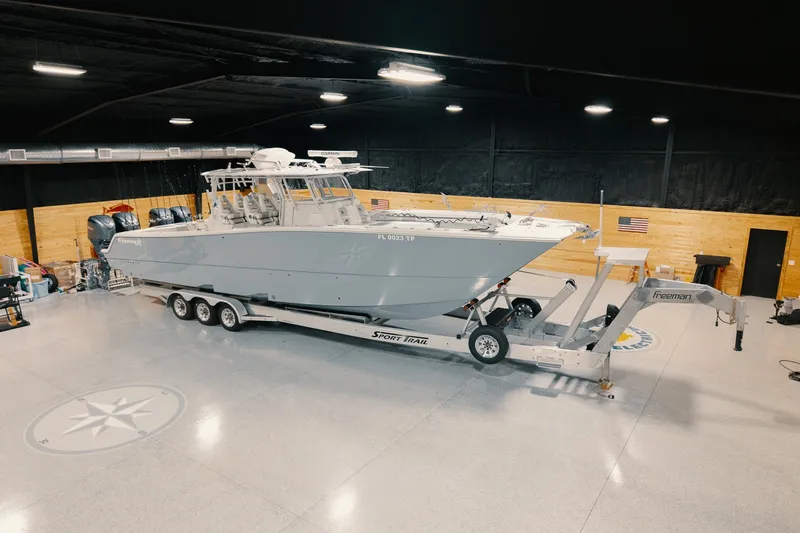 Slide: The Image of 2023 Freeman 42LR boat on trailer in spacious indoor garage. - 23