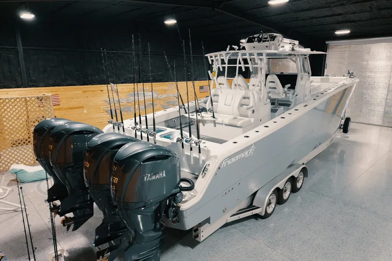 Slide: The Image of 2023 Freeman 42LR boat with Yamaha engines in a garage setting. - 24
