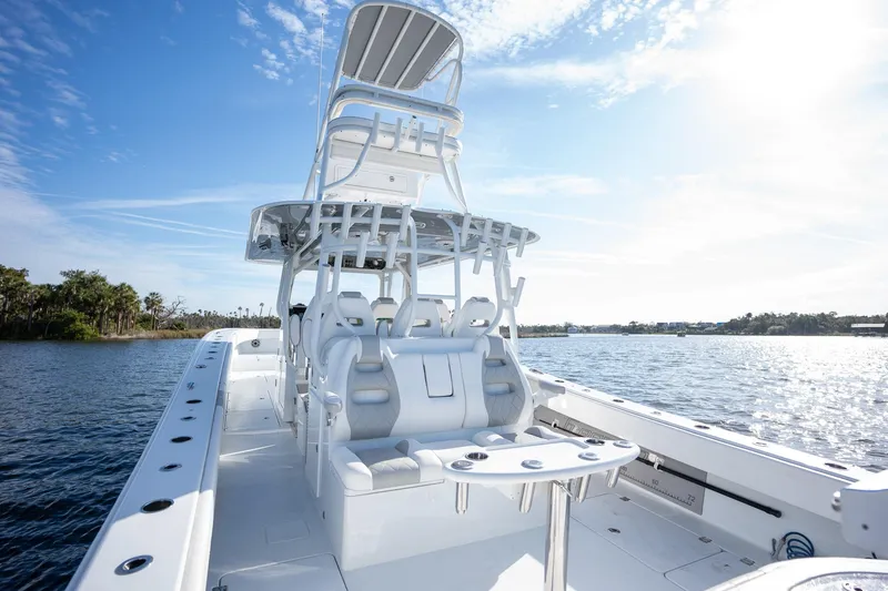 Slide: The Image of 2023 Freeman 42LR boat on water, featuring spacious deck and seating under clear sky. - 13