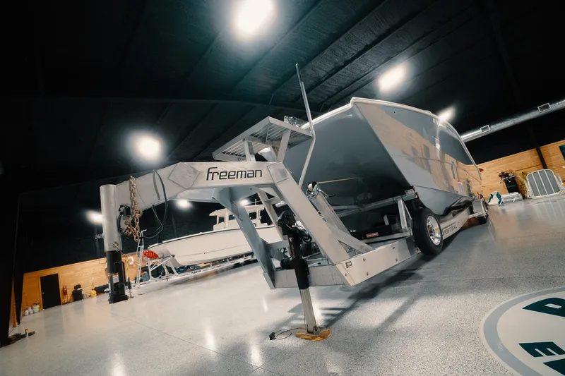 Slide: The Image of Freeman 42LR 2023 boat on trailer in indoor showroom setting. - 31
