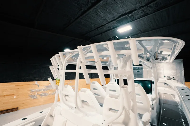 Slide: The Image of 2023 Freeman 42LR boat interior with rod holders and seating, under indoor lighting. - 56