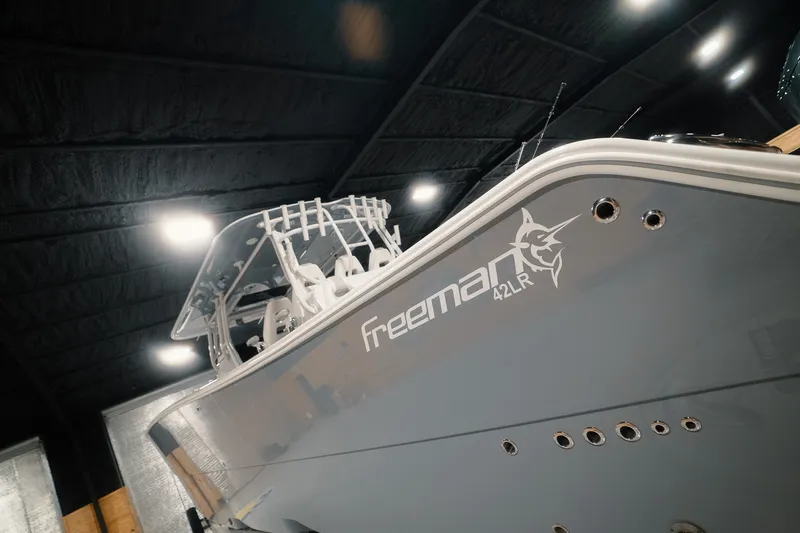 Slide: The Image of 2023 Freeman 42LR boat in a dimly lit indoor setting, showcasing sleek design. - 37