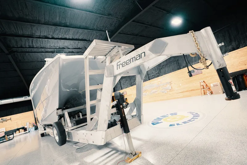 Slide: The Image of Freeman 42LR 2023 boat on trailer in a spacious indoor facility. - 28