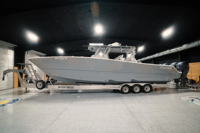 The Image of 2023 Freeman 42LR boat on a Sport Trail trailer in a showroom. - 0