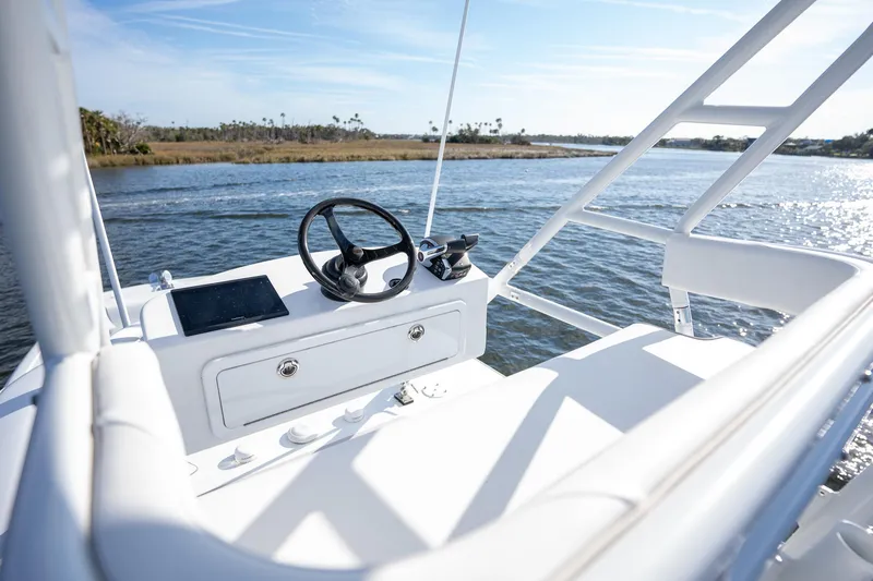 Slide: The Image of Freeman 42LR 2023 boat helm with steering wheel and controls on a sunny day. - 17