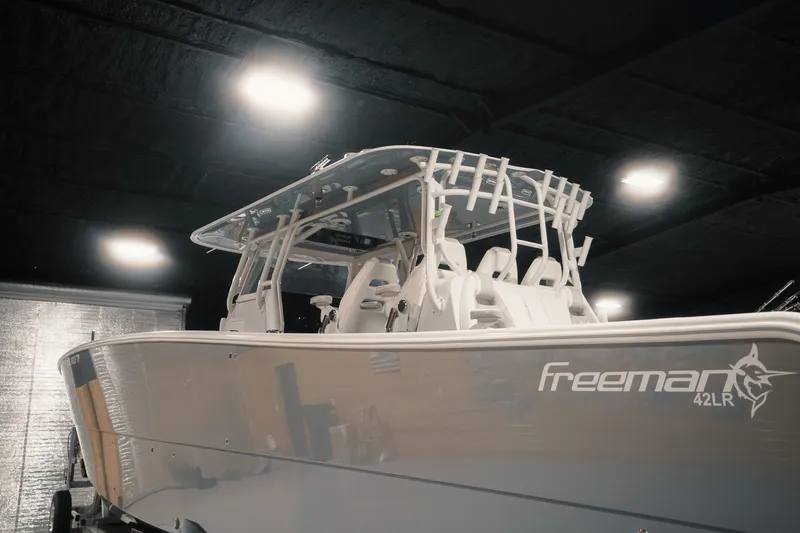 Slide: The Image of 2023 Freeman 42LR boat in showroom, sleek design under bright lights. - 36