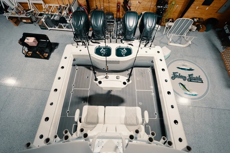 Slide: The Image of 2023 Freeman 42LR boat interior with fishing rods and seating, in a garage setting. - 60