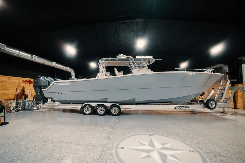 Slide: The Image of 2023 Freeman 42LR boat on trailer in a well-lit indoor space. - 33