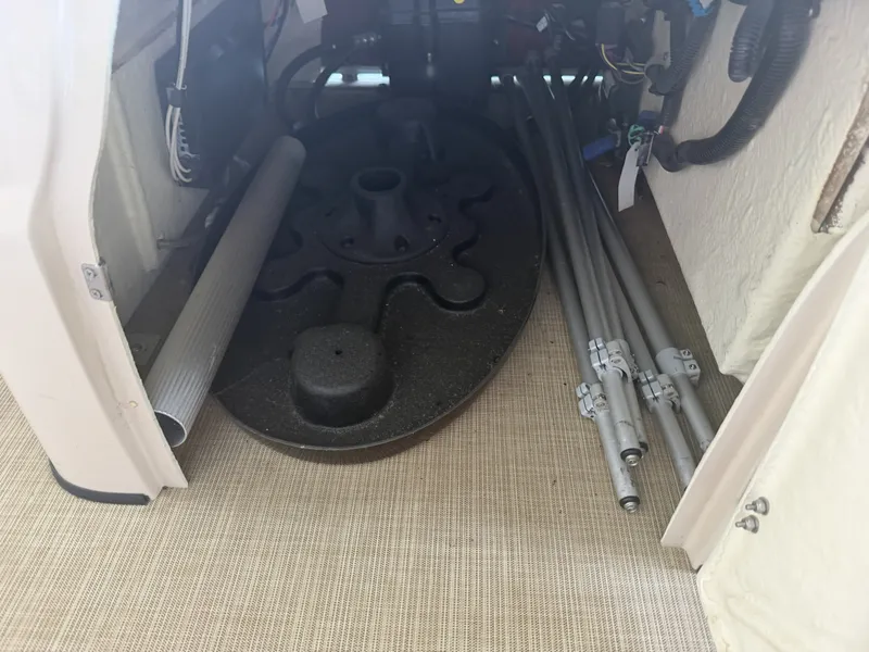 Slide: The Image of A storage area with pipes and a round black part on a boat. - 23