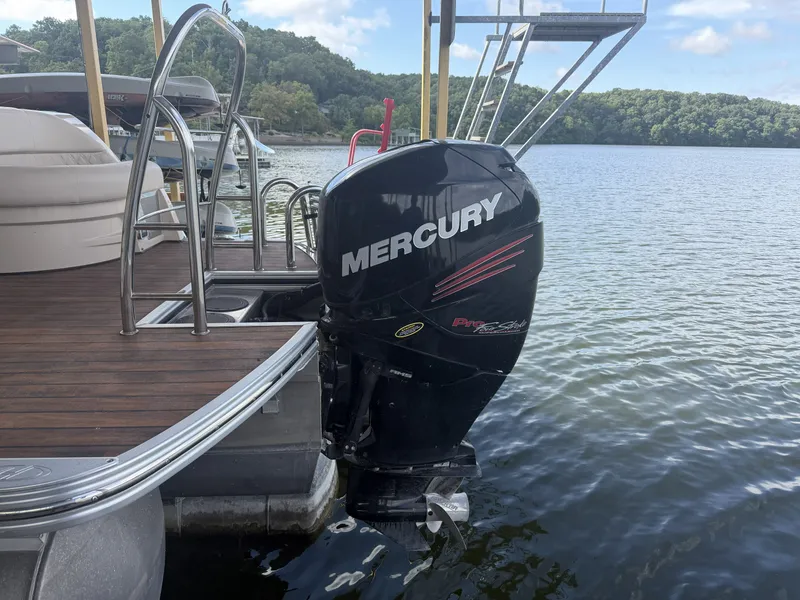 Slide: The Image of A Mercury outboard motor on a Harris 250 GM pontoon boat docked at a wooden pier. - 21