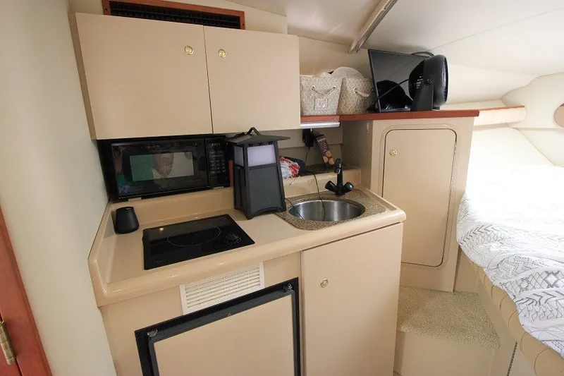 Slide: The Image of 2001 Cruisers Yachts 2870 Express cabin interior with kitchenette and bed. - 14