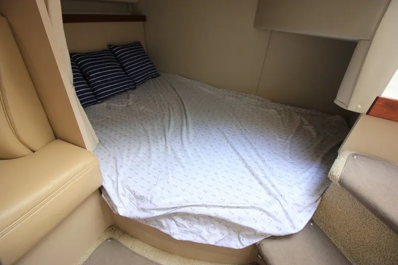 Slide: The Image of 2001 Cruisers Yachts 2870 Express cabin with cozy bed and striped pillows. - 21
