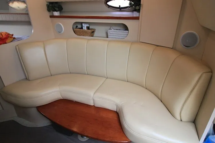 Slide: The Image of 2001 Cruisers Yachts 2870 Express interior with beige leather seating and wooden table. - 19