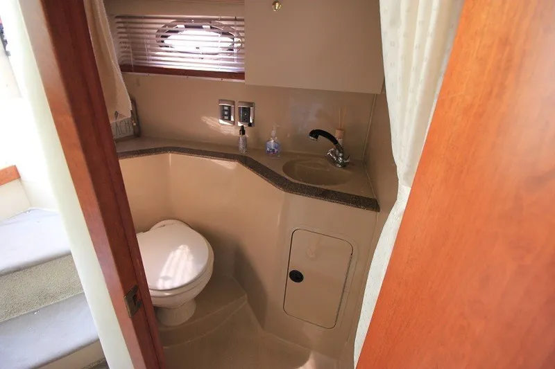 Slide: The Image of 2001 Cruisers Yachts 2870 Express bathroom with sink, toilet, and window. - 17