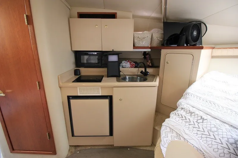 Slide: The Image of 2001 Cruisers Yachts 2870 Express cabin kitchen with sink, microwave, and storage. - 15