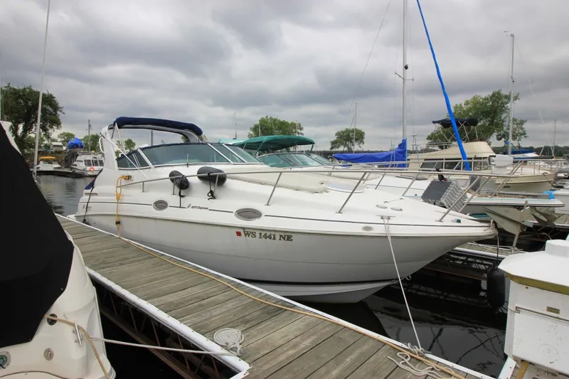 The Image of 2001 Cruisers Yachts 2870 Express docked at marina under cloudy sky. - 0
