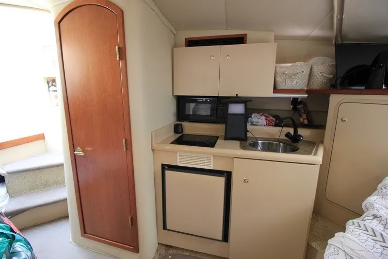 Slide: The Image of 2001 Cruisers Yachts 2870 Express cabin kitchen with sink, microwave, and storage. - 16