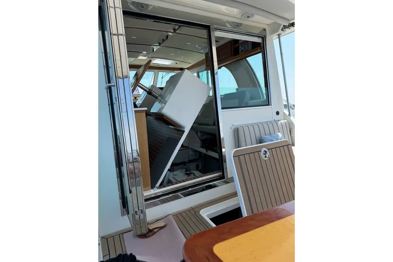Slide: The Image of 2019 Back Cove 41 yacht interior with open sliding door and visible seating area. - 5