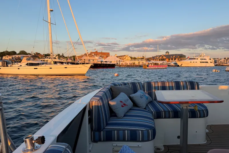 Slide: The Image of Back Cove 41 yacht interior with striped seating, overlooking marina at sunset, 2019 model. - 3