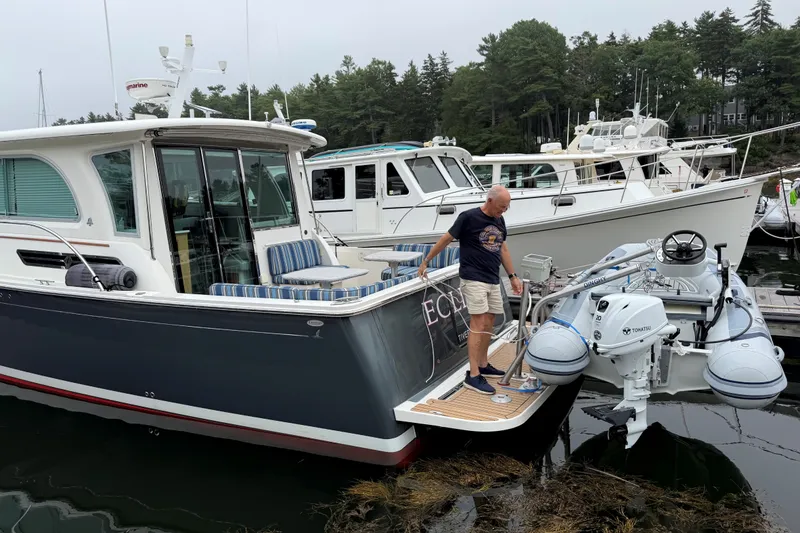Slide: The Image of Man on 2019 Back Cove 41 yacht with inflatable dinghy, docked in marina. - 12