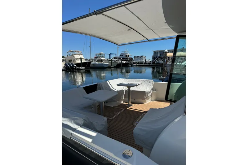 Slide: The Image of 2019 Back Cove 41 yacht with covered deck, docked at marina under clear blue sky. - 11