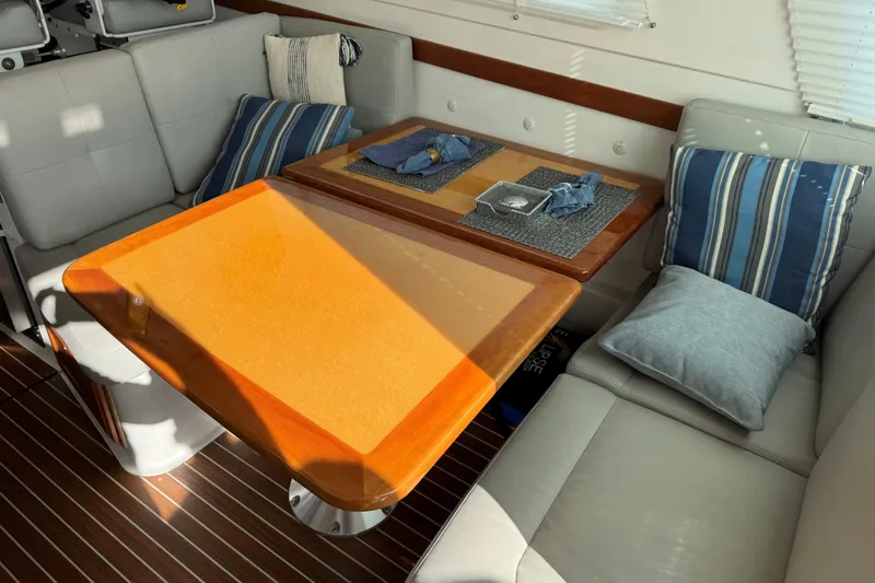 Slide: The Image of 2019 Back Cove 41 yacht interior with cushioned seating and wooden dining table. - 8