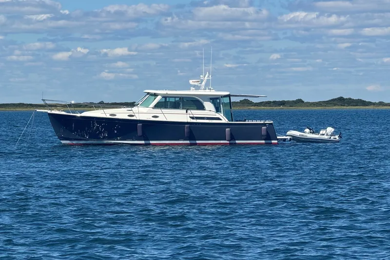 The Image of 2019 Back Cove 41 yacht anchored on calm blue waters under a partly cloudy sky. - 0