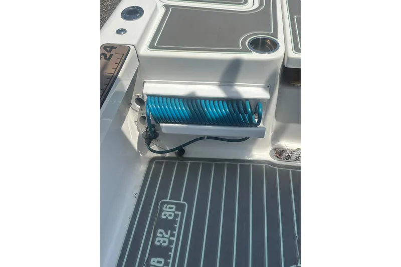 Slide: The Image of 2018 Sea Pro 248 Bay boat deck with coiled blue hose and measurement markings. - 39