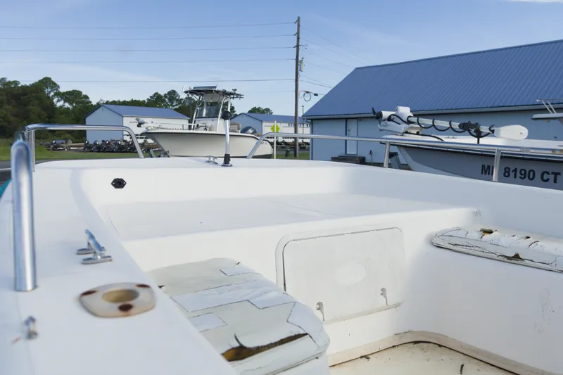 Slide: The Image of 2008 Sundance B20CCR boat with worn seating, parked near storage buildings. - 9