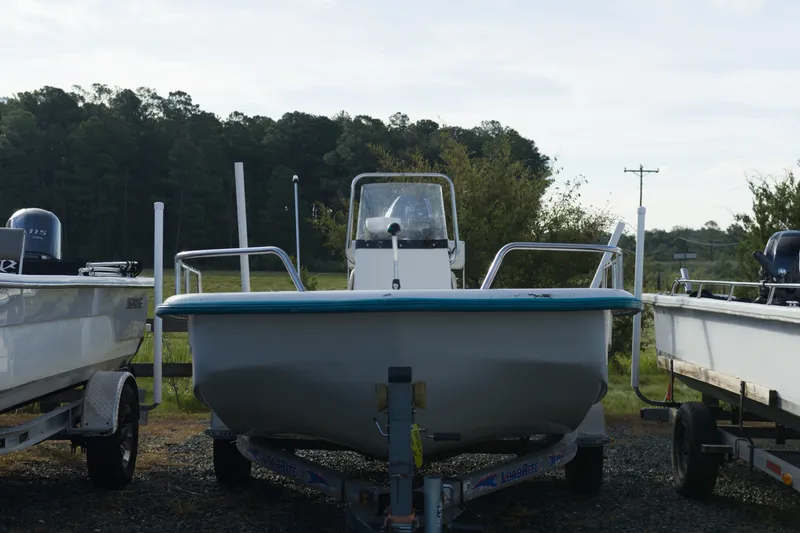 Slide: The Image of 2008 Sundance B20CCR boat on trailer, parked outdoors with trees in the background. - 2