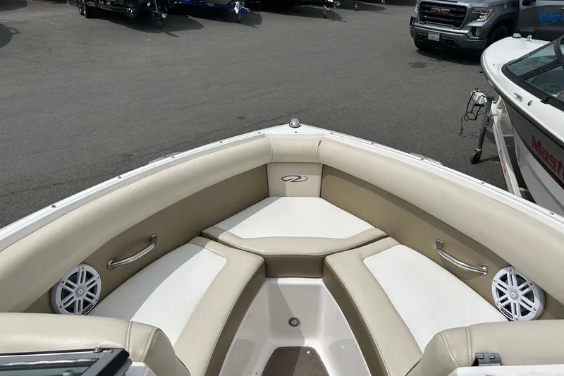 Slide: The Image of 2011 Regal 2100 Bowrider boat interior with beige seating and speakers. - 8