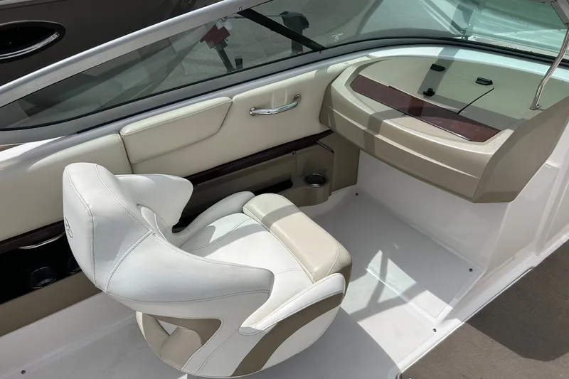 Slide: The Image of 2011 Regal 2100 Bowrider interior with white and beige seating, dashboard view. - 6
