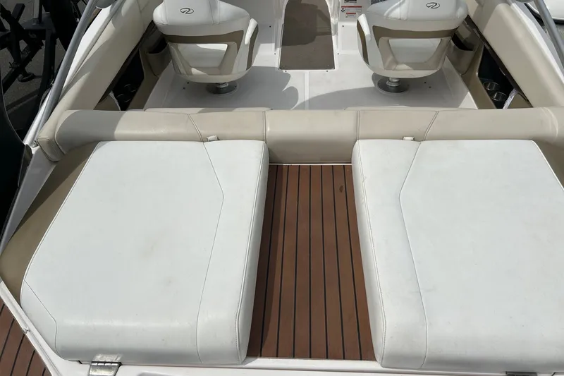 Slide: The Image of Interior view of a 2011 Regal 2100 Bowrider boat with white seating and wooden flooring. - 11