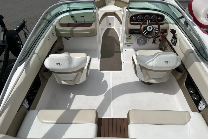 Slide: The Image of 2011 Regal 2100 Bowrider interior with beige seating and modern dashboard. - 7