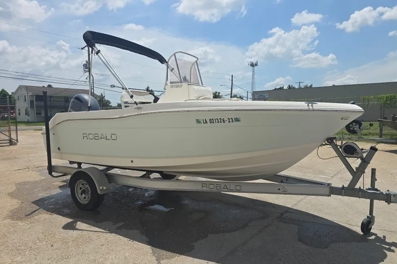 Slide: The Image of 2018 Robalo R180 Center Console boat on trailer under sunny sky. - 4
