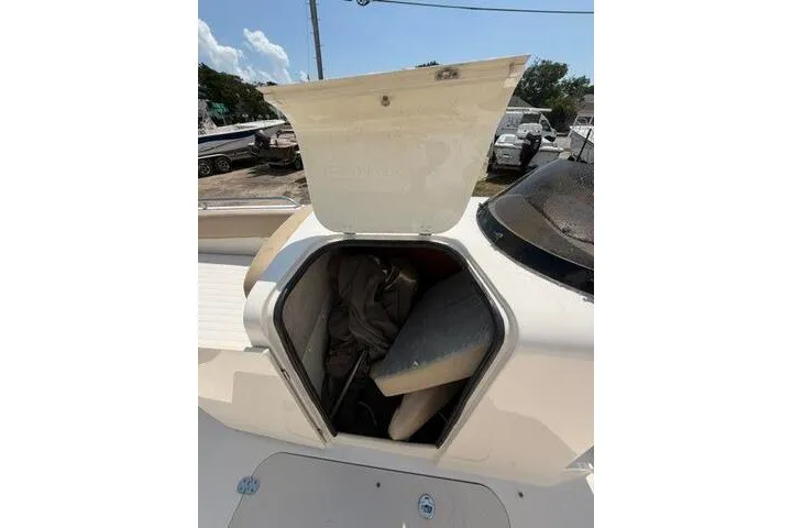 Slide: The Image of 2018 Stingray 212 SC boat storage compartment open, revealing cushions and gear inside. - 24