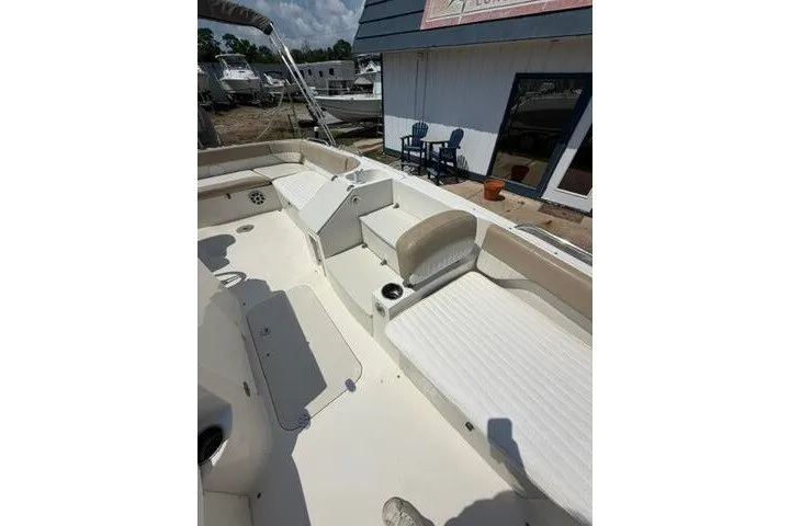 Slide: The Image of 2018 Stingray 212 SC boat interior with beige seating and cup holders. - 15