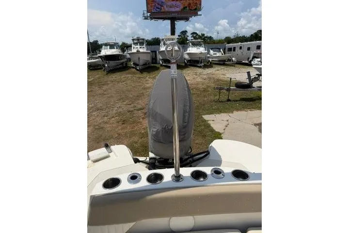 Slide: The Image of 2018 Stingray 212 SC boat stern view with covered engine and rod holders. - 26