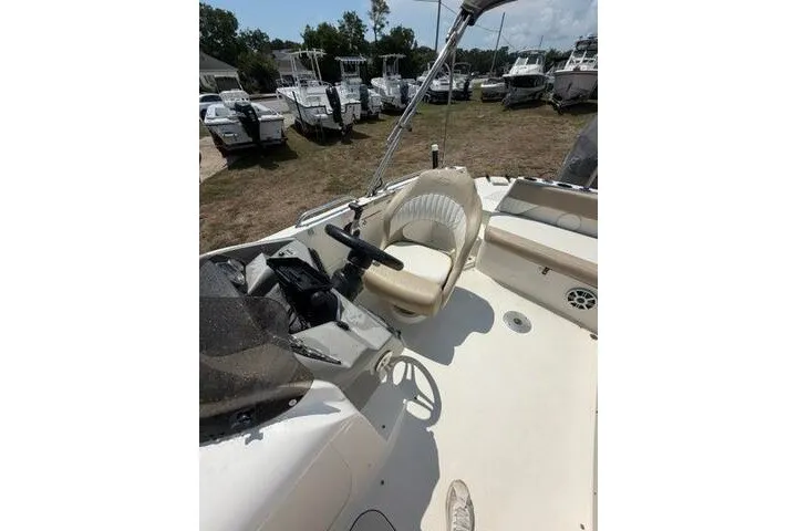 Slide: The Image of 2018 Stingray 212 SC boat interior with steering wheel and seating area. - 19