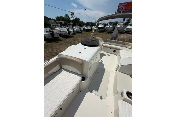 Slide: The Image of 2018 Stingray 212 SC boat interior with white seating, parked among other boats. - 14