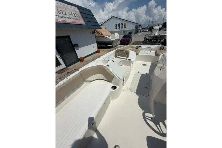 Slide: The Image of 2018 Stingray 212 SC boat interior with seating and steering wheel under a sunny sky. - 23