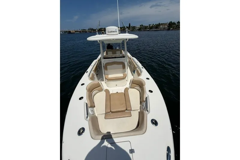 Slide: The Image of 2018 Key West 263 FS boat with beige seating, docked on calm water. - 8
