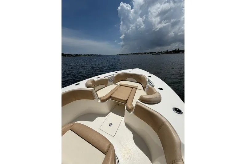 Slide: The Image of 2018 Key West 263 FS boat with tan seating on open water under cloudy sky. - 7
